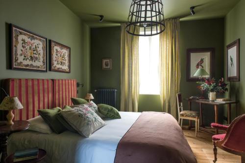 a bedroom with a bed with green walls and a window at La Villa Augustine in Dieppe