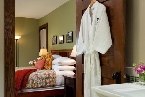 a hotel room with a bed and a robe on a door at The Buckingham Inn in Madison