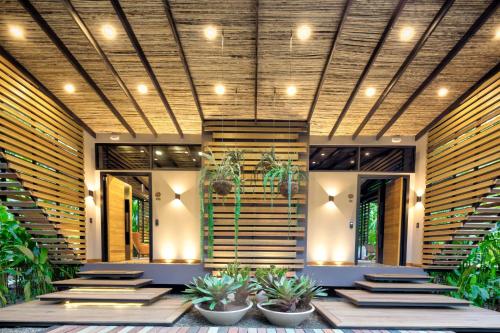 a lobby with stairs and potted plants at awā Beachfront Hotel in Puerto Viejo