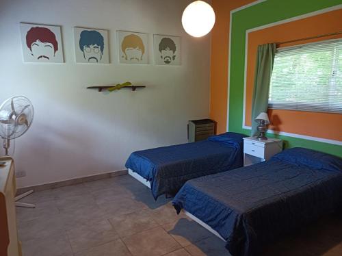 1 dormitorio con 2 camas, ventana y ventilador en Casa de campo Miramar Norte en Miramar