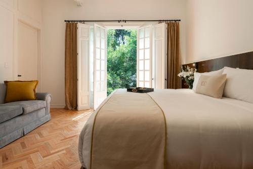 a bedroom with a large bed and a large window at Roso Guest House in Mexico City