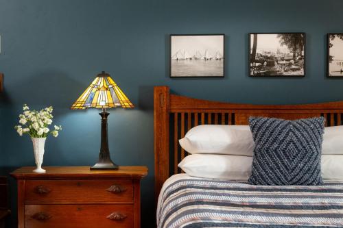 a bedroom with a bed and a lamp on a night stand at The Buckingham Inn in Madison