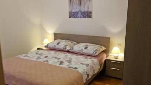 a bedroom with a bed with two pillows on it at Apartment Karmen in Šilo