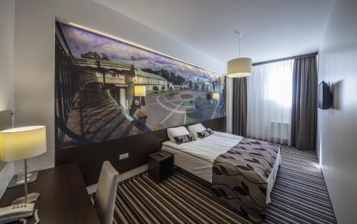 a hotel room with a bed and a painting on the wall at Vilnius City Hotel in Vilnius
