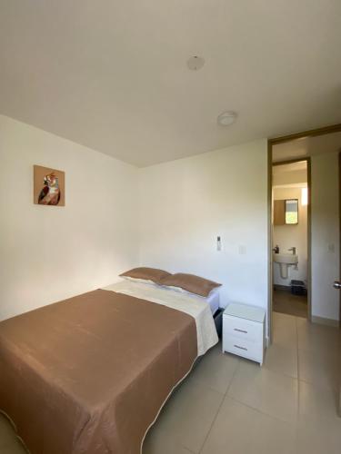 a bedroom with a large bed and a bathroom at Apartment near to Bello Horizonte Beach, Santa Marta Airport in Santa Marta