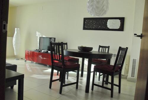 jadalnia ze stołem, krzesłami i telewizorem w obiekcie Apartaments Can Negret w mieście Sitges