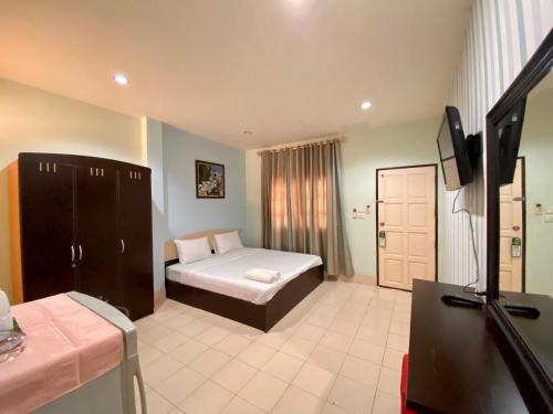 a bedroom with a bed and a tv in a room at Pachumas Hotel in Karon Beach