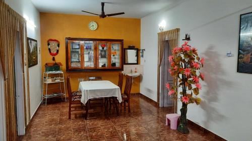a dining room with a table and a clock on the wall at Gokulam Homestay in Kovalam