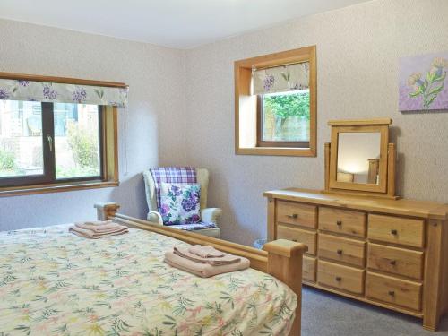Schlafzimmer mit einem Bett, einer Kommode und einem Spiegel in der Unterkunft Glen Rosa in Dalrymple