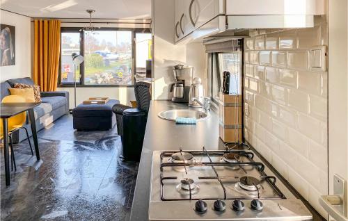 een keuken met een fornuis bovenste oven naast een woonkamer bij 2 Bedroom Pet Friendly Home In Breukelen in Breukelen