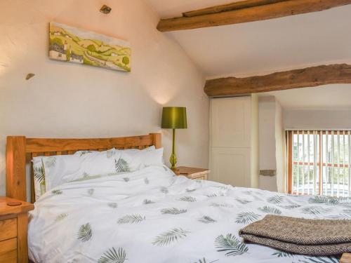 a bedroom with a white bed with a wooden headboard at The Cottage - Ukc6140 in Cartmel