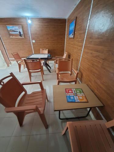 um quarto com cadeiras e mesas e uma mesa em Majkhali Woods, Ranikhet, By Himalayan Eco Lodges em Rānīkhet