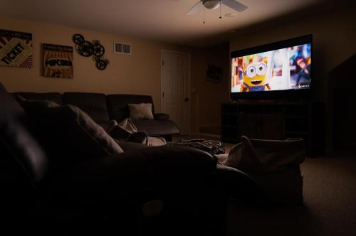 a living room with a couch and a flat screen tv at Epic View A Luxury House on a Hill River 10 min in Kernville