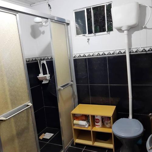 a small bathroom with a toilet and a shower at Instituto Bugio Ruivo in Eldorado do Sul 