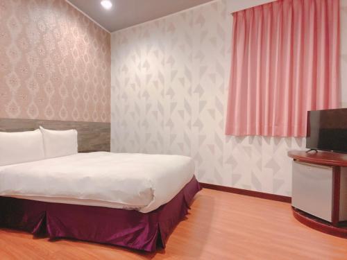 1 dormitorio con 1 cama y TV. en Centre Hotel, en Kaohsiung