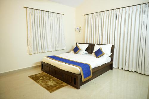 a bedroom with a bed with blue and white pillows at Shri Mahamaya in Panaji