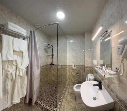 y baño con ducha, aseo y lavamanos. en Khan Palace Hotel, en Yakkasaray