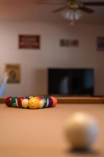 a group of cue balls on a pool table at Lazy Squirrel - Cozy Family House with Full Game Room in Kernville