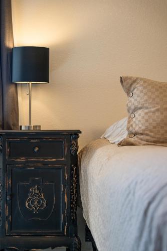 a bedroom with a bed and a table with a lamp at Lazy Squirrel - Cozy Family House with Full Game Room in Kernville
