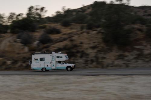 an rv driving down a road near a mountain at Lazy Squirrel - Cozy Family House with Full Game Room in Kernville