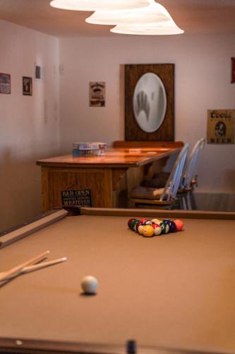 a pool table with a ball in a room at Lazy Squirrel - Cozy Family House with Full Game Room in Kernville