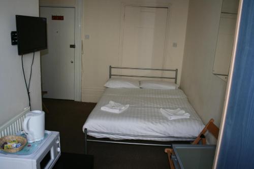 a bedroom with a bed with two towels on it at Paddington Flats in London