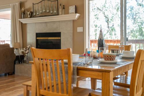 a dining room with a table with chairs and a fireplace at Lazy Squirrel - Cozy Family House with Full Game Room in Kernville