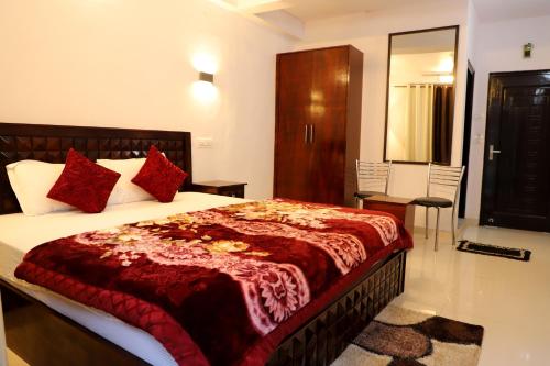 a bedroom with a large bed with red pillows at Royal Inn Rewalsar in Malther