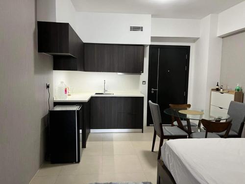 a room with a kitchen and a table and a bed at Aeon Tower 2627 in Davao City