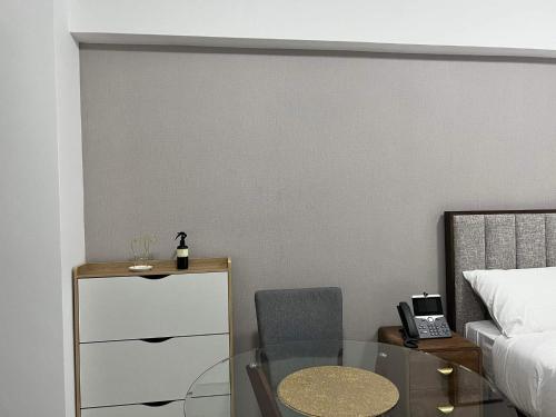 a bedroom with a glass table and a bed at Aeon Tower 2627 in Davao City