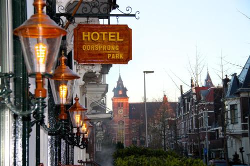 a sign for a hotel on a city street with buildings at Hotel Oorsprongpark in Utrecht