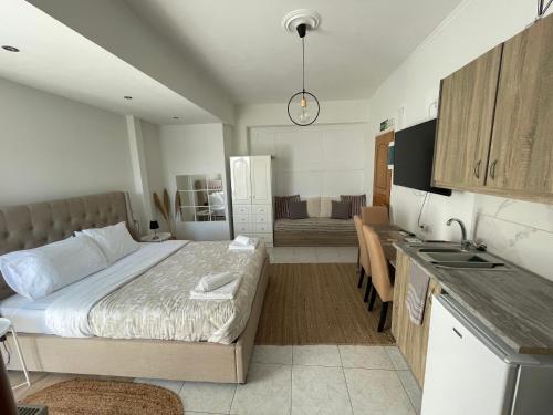 małą sypialnię z łóżkiem i kuchnią w obiekcie Greece Apartments Now w mieście Patras