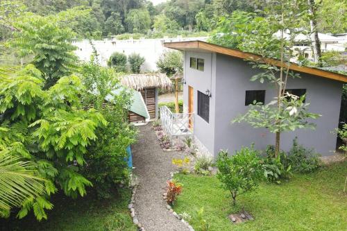 un jardín con una casa pequeña y un patio en CASA NOIL, Beautiful Eco House near the beach!, en Puerto Viejo