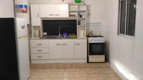 een kleine keuken met witte kasten en een koelkast bij El jazmín in Villa Santa Cruz del Lago