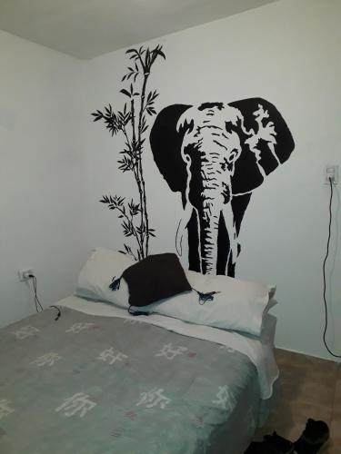 een slaapkamer met een olifant op de muur bij El jazmín in Villa Santa Cruz del Lago
