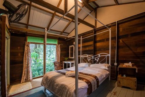 a bedroom with a bed in a room with a window at Nature Fruit Farm - Private Estate in Balik Pulau