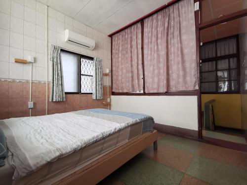 a bedroom with a bed and two windows at 一起-台南 雙人套房 in Tainan