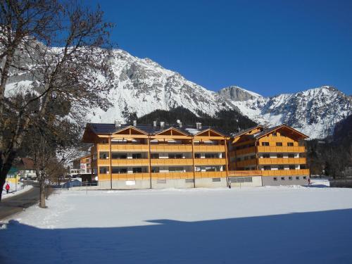 a large building in front of a snow covered mountain at Appartements Ramsau am Dachstein by Schladmingurlaub in Ramsau am Dachstein