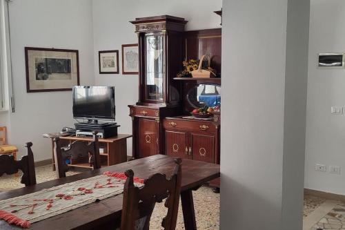 un soggiorno con tavolo in legno e TV di La Casa di Lucia: Grande appartamento con balcone a Brescia