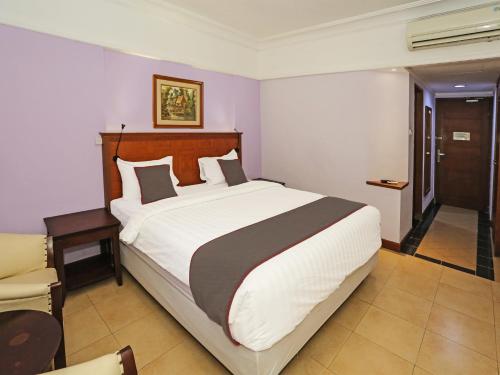 ein Schlafzimmer mit einem großen Bett in einem Zimmer in der Unterkunft Super OYO Collection O 91898 Series Hotel Kuningan in Jakarta