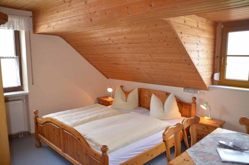 - une chambre avec un grand lit et un plafond en bois dans l'établissement Kollerhof, à Neunburg vorm Wald