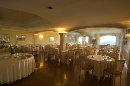 a restaurant with tables and chairs with white tablecloths at Hotel Monteconero in Sirolo