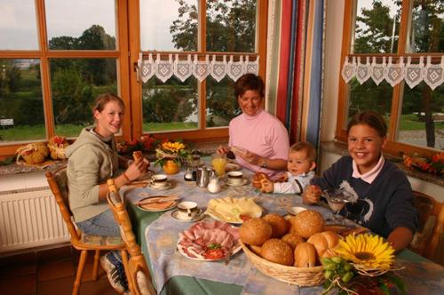 a group of people sitting at a table with food at Kollerhof in Neunburg vorm Wald