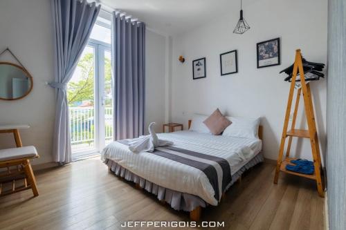 a bedroom with a bed with a ladder next to a window at Sele House in Ha Tien