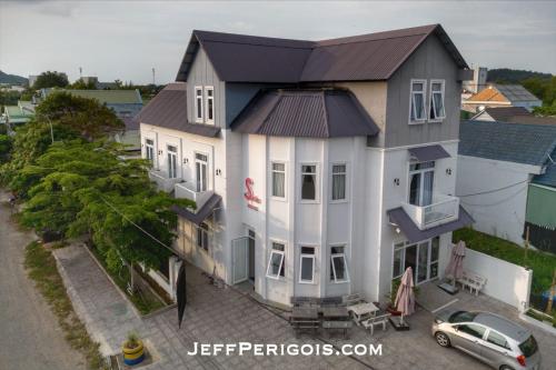 a large white house with a car in front of it at Sele House in Ha Tien