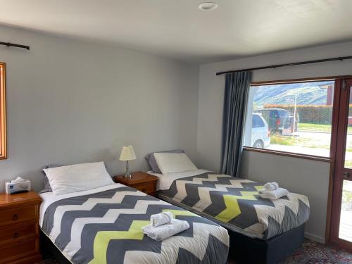 a bedroom with two beds and a large window at Visitor Rooms Prepay & Self Check in in Queenstown