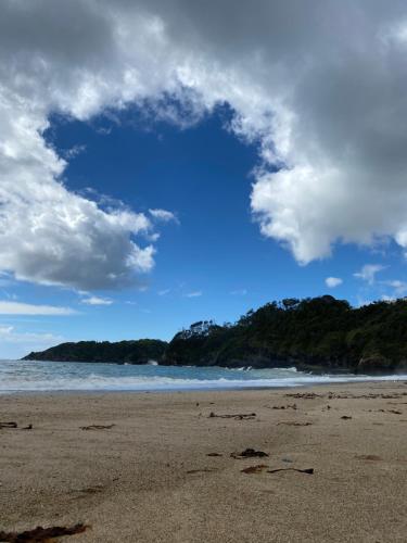 a view of a beach with a blue sky and clouds at Beachfront Retreat - Ducted Air - Free Wifi in Coffs Harbour