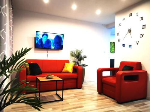 sala de estar con sofá rojo y silla en Chillout Apart 4You, en Świeradów-Zdrój