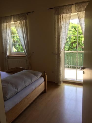 a bedroom with a bed and a large window at Gut Tausendbachl in Regen