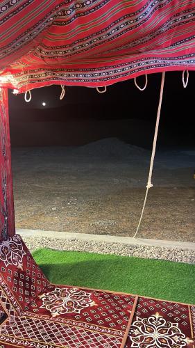 a chair under a tent with a green field under it at Home X4 in Al Wāşil